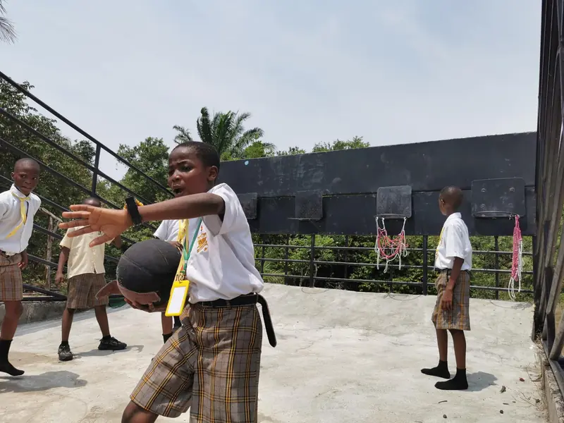 A student with a basketball on a school rooftop court