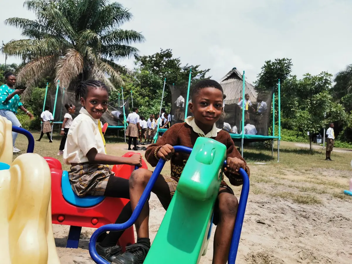 Two Chosen Kiddies pupils smiling on a playground seesaw