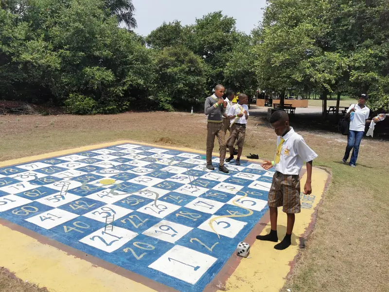 A student playing life-size snakes and ladders